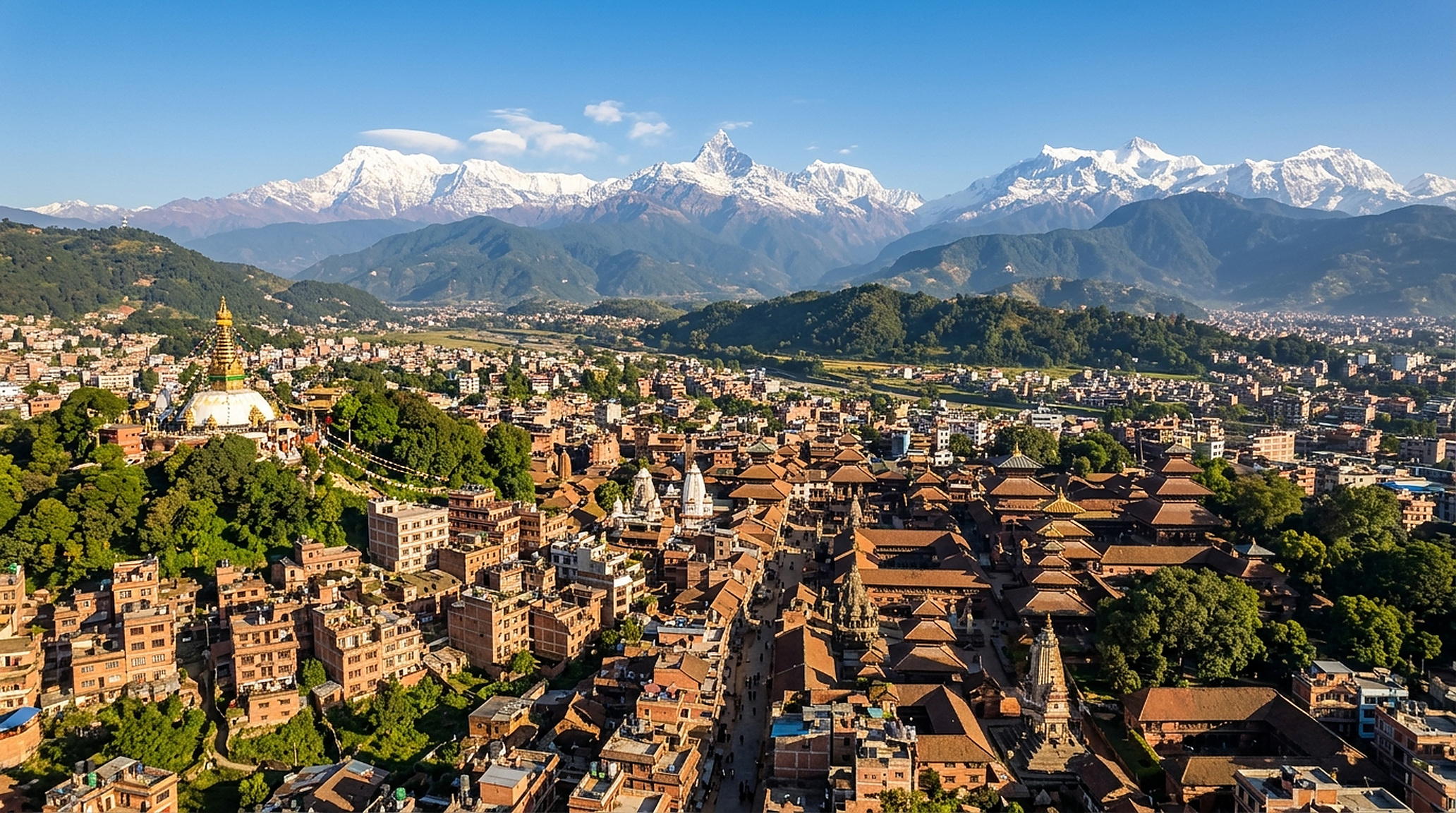 Kathmandu valley from above: houses and temple roofs with the mountains behind.